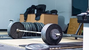 Barbell loaded with weights sitting on the floor https://get-strong.fit/Fitness